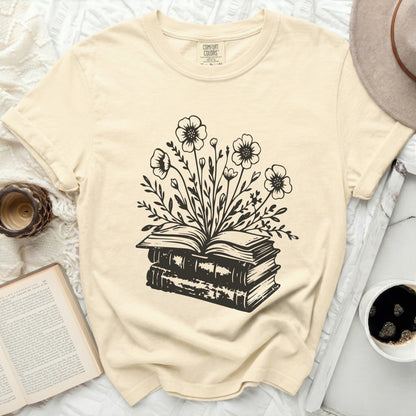T-shirt with black ink drawing of an open book with flowers blooming from pages.