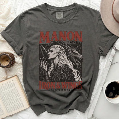 Dark grey t-shirt graphic of Manon Blackbeak and dragon, with text "MANON BLACKBEAK" and "IRON & WINGS THE THIRTEEN".