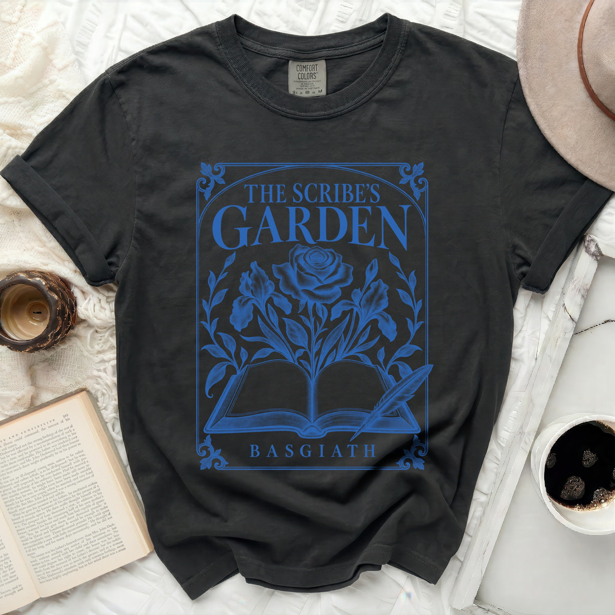 Black t-shirt with blue graphic of open book, rose, and text "The Scribe's Garden Basgiath".
