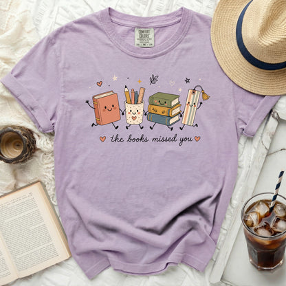 Lavender Comfort Colors t-shirt with cartoon books and the text "the books missed you".