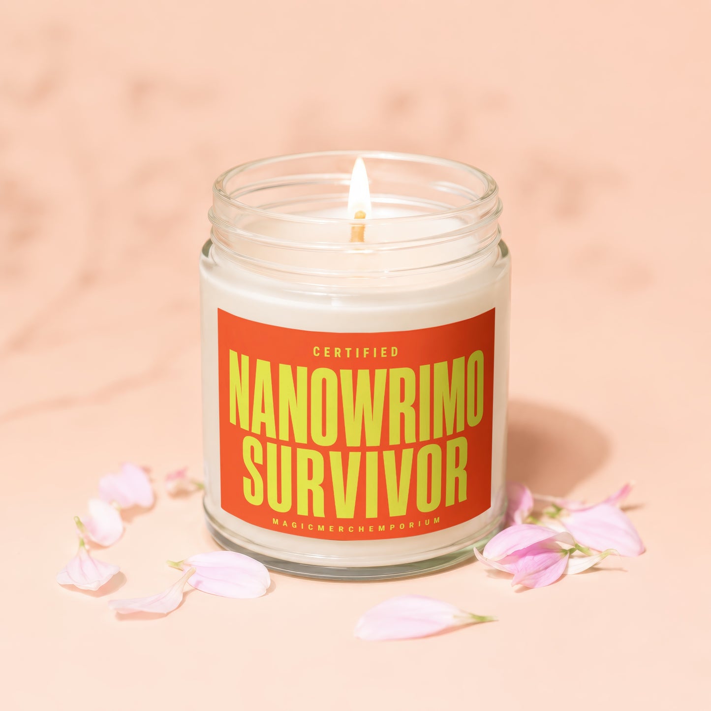 Lit candle in a glass jar with an orange label reading "CERTIFIED NANOWRIMO SURVIVOR".