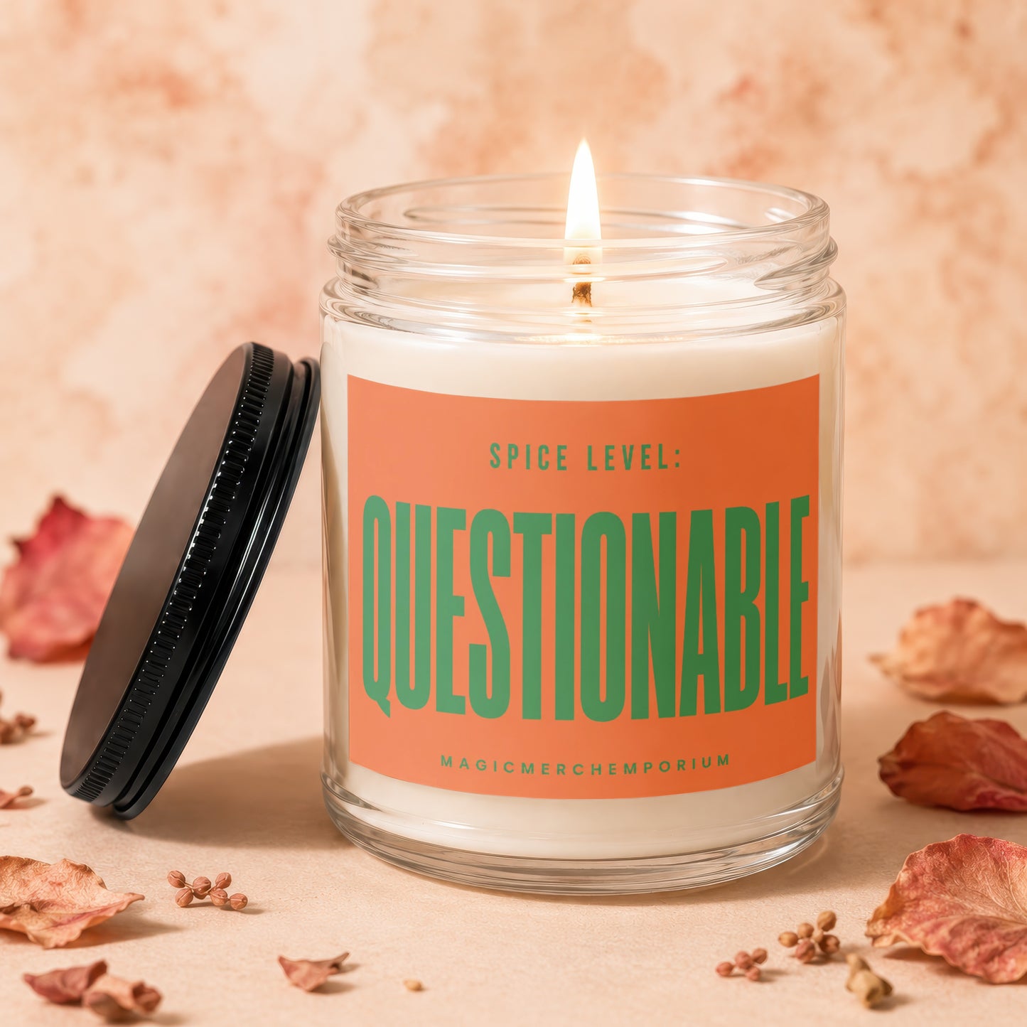 Jar candle with lid off, shows "Spice Level: Questionable" on an orange label.