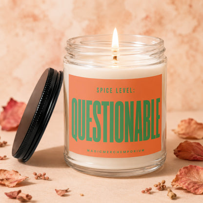 Jar candle with lid off, shows "Spice Level: Questionable" on an orange label.