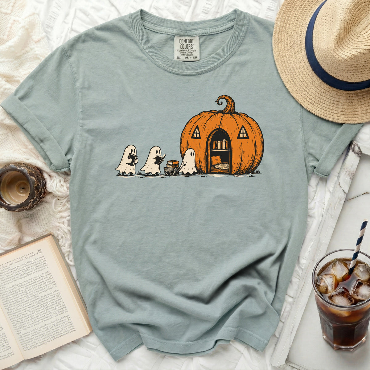 Ghosts reading books near a pumpkin house with a bookshelf inside.