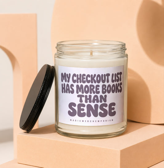 Candle in glass jar with lid off, reading "My checkout list has more books than sense".