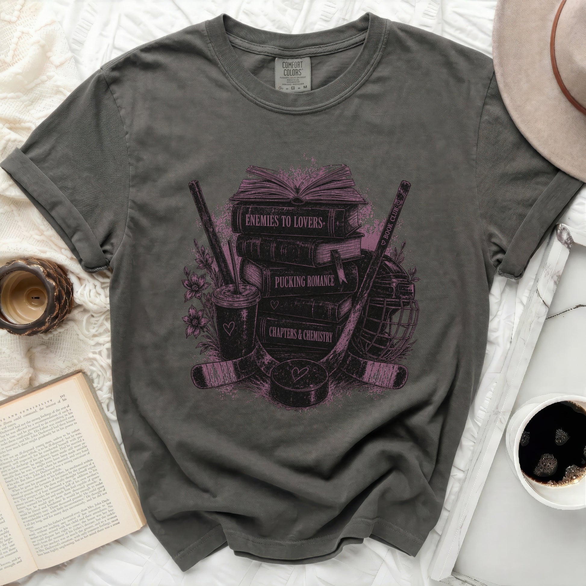 Dark gray t-shirt with "Enemies to Lovers" stacked books and hockey gear design.