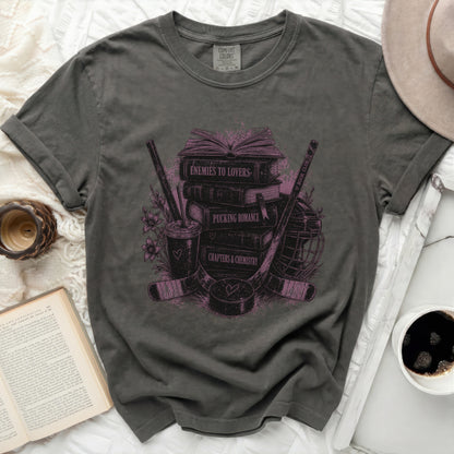 Dark gray t-shirt with "Enemies to Lovers" stacked books and hockey gear design.
