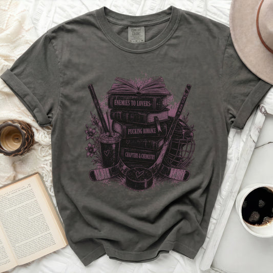 Dark gray t-shirt with "Enemies to Lovers" stacked books and hockey gear design.