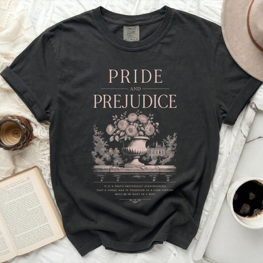Dark grey Comfort Colors t-shirt with "Pride and Prejudice" text and floral illustration.