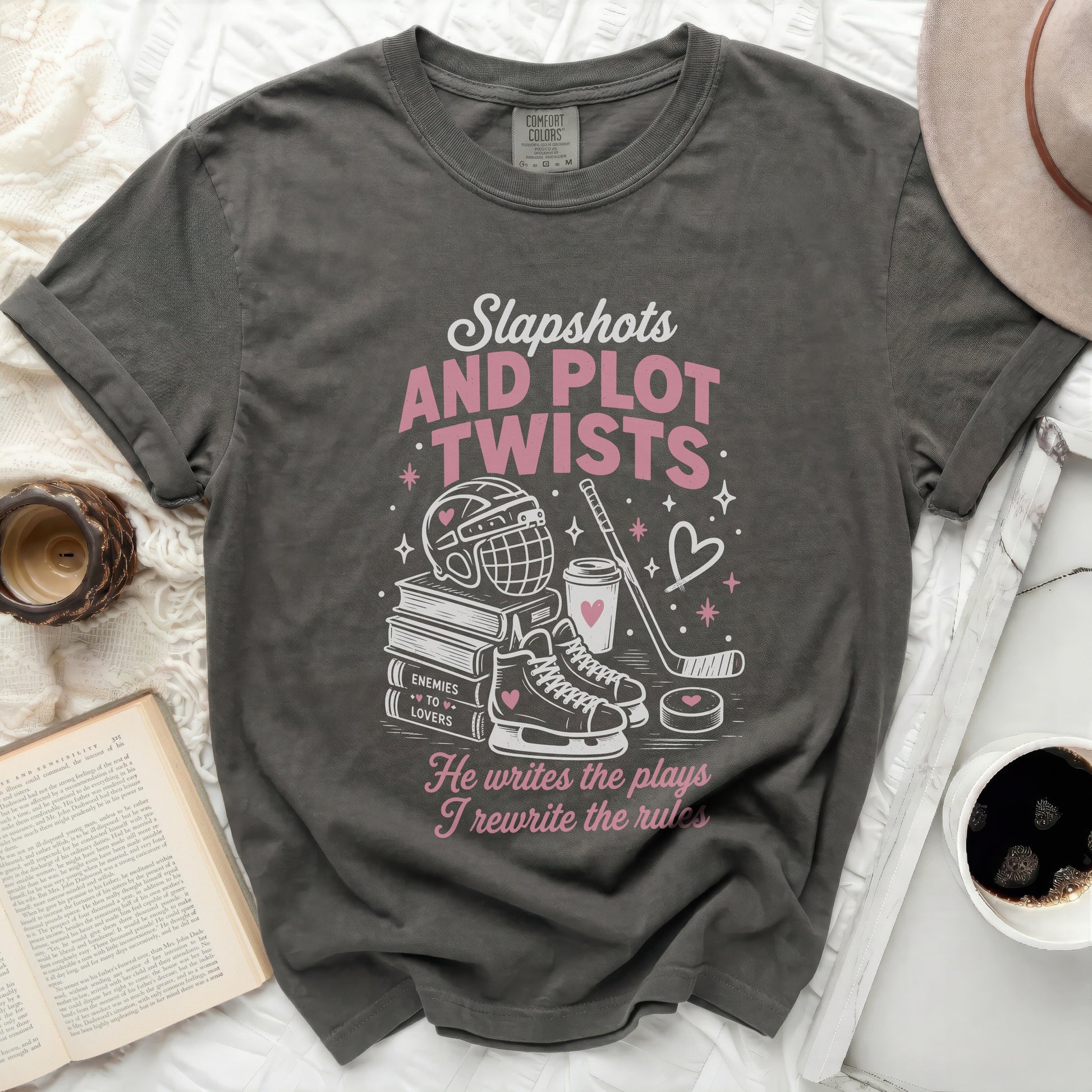 Dark gray t-shirt with "Slapshots and Plot Twists" text and hockey graphics.