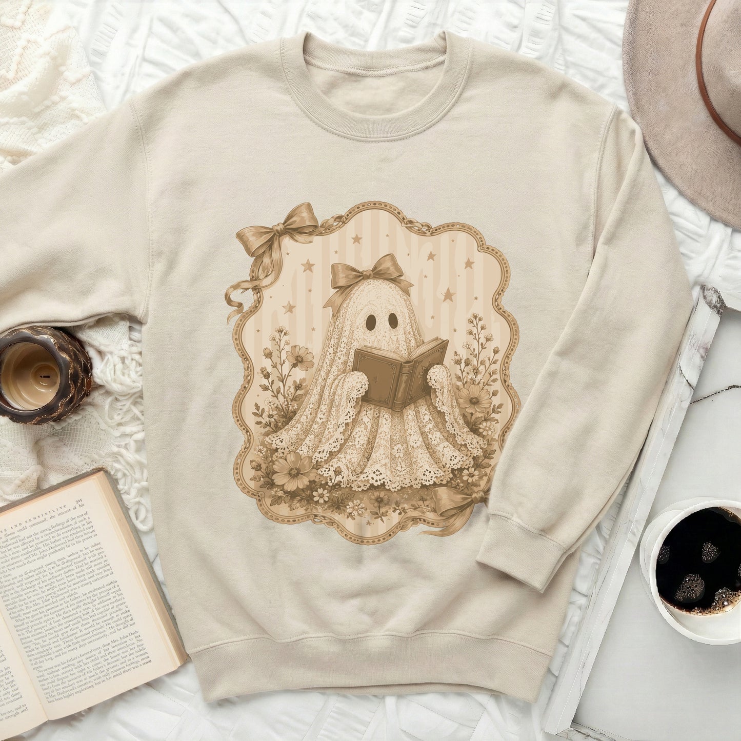 Cream sweatshirt with a lace ghost reading a book illustration.