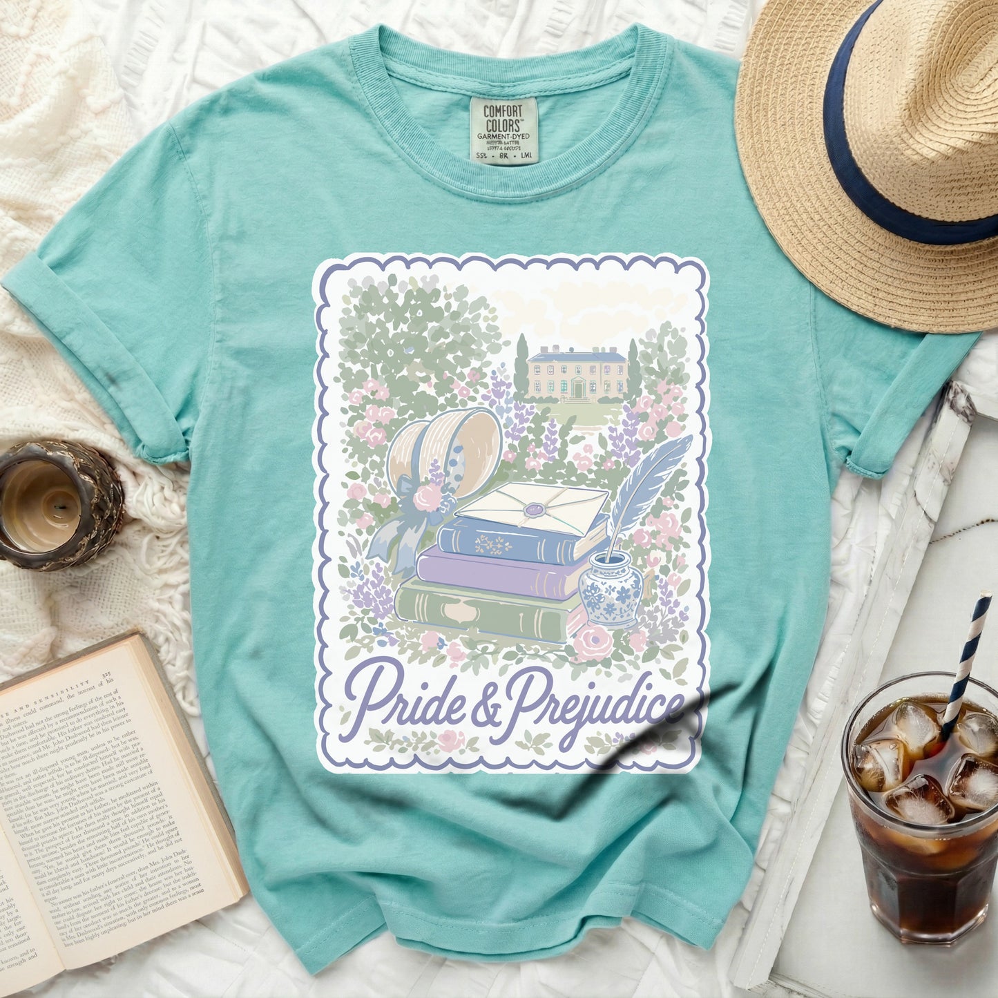 Turquoise t-shirt with "Pride & Prejudice" graphic of books, hat, and estate.