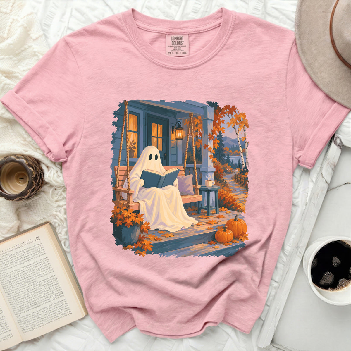 Ghost reading a book on a porch swing with pumpkins and autumn leaves.