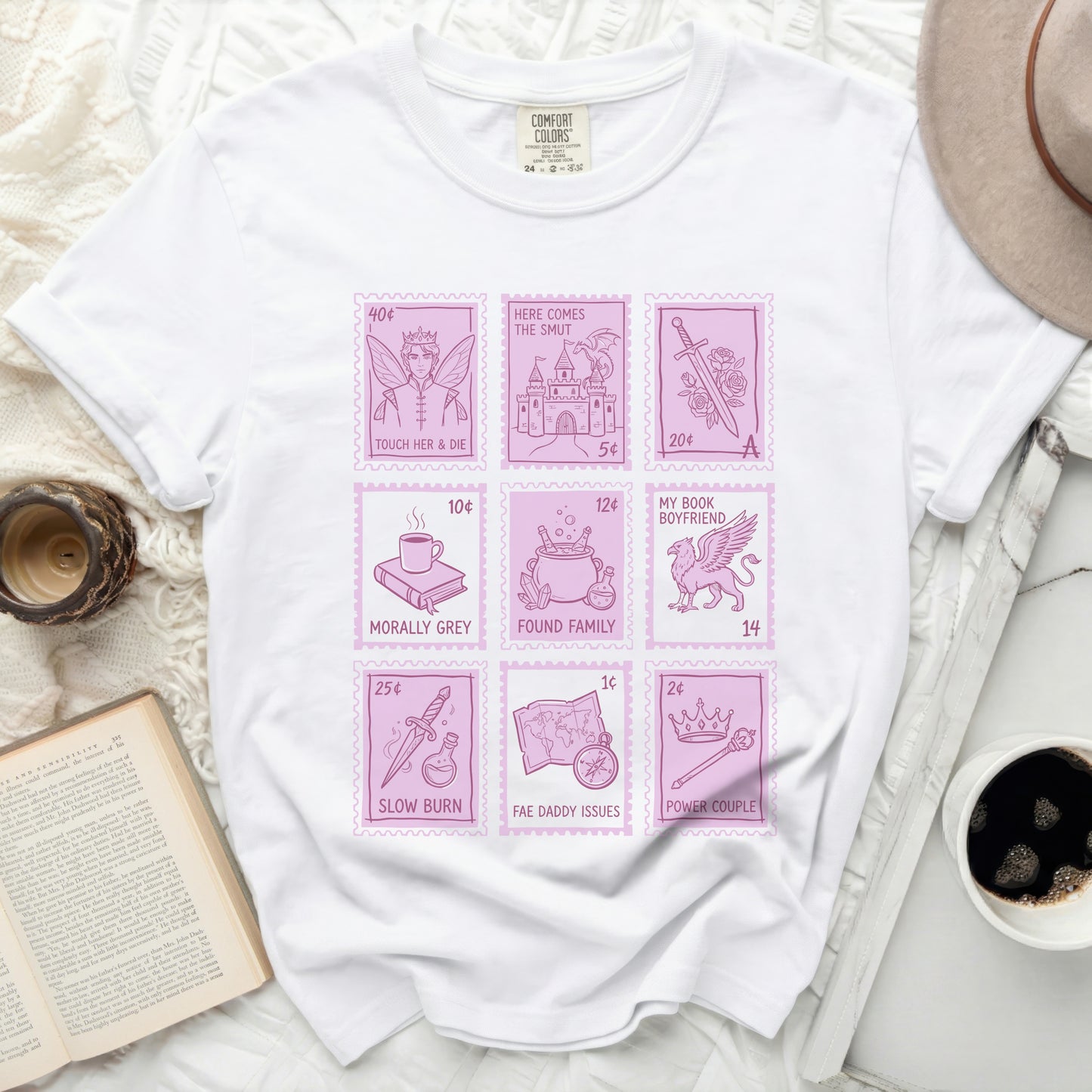 White t-shirt with four rows of postage stamps featuring romance novel tropes.