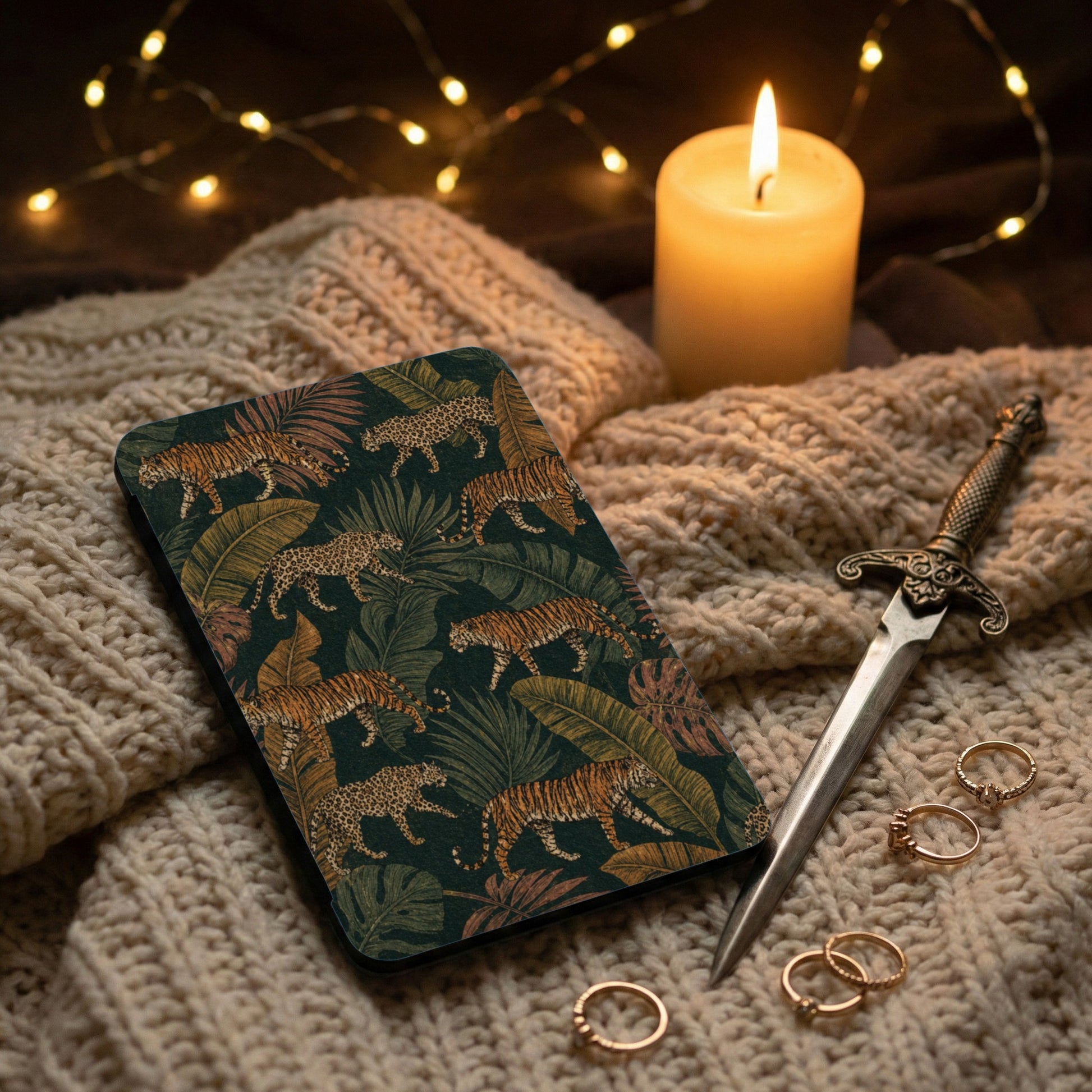 Dark journal with tiger and leopard jungle print on a cream cable knit surface.