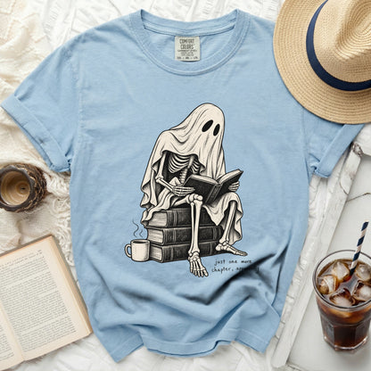 Skeleton ghost reading books with "just one more chapter, apparently" text.
