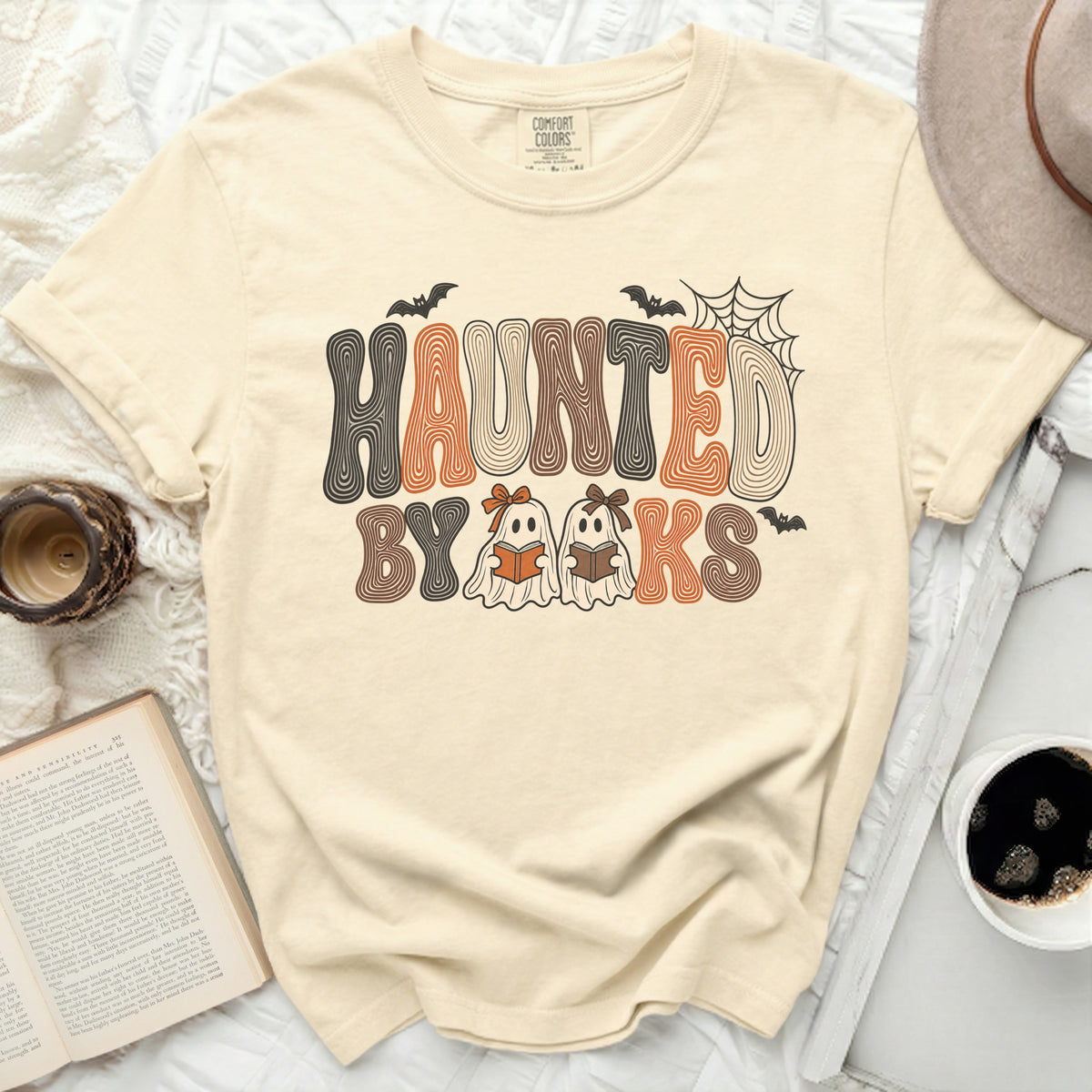 Cream t-shirt with "Haunted By Books" text and two ghosts reading books.