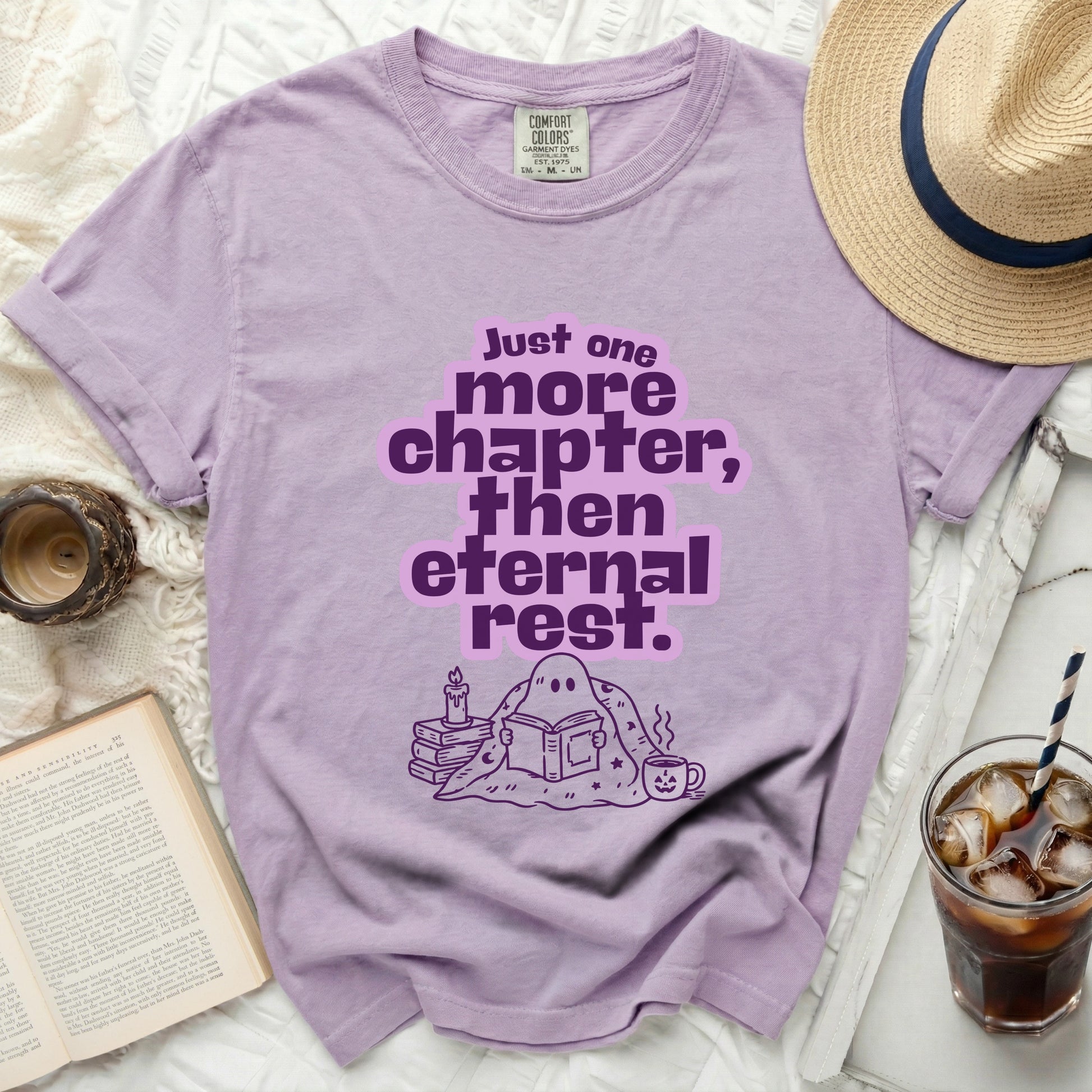 Purple t-shirt with ghost reading a book and text "Just one more chapter, then eternal rest."