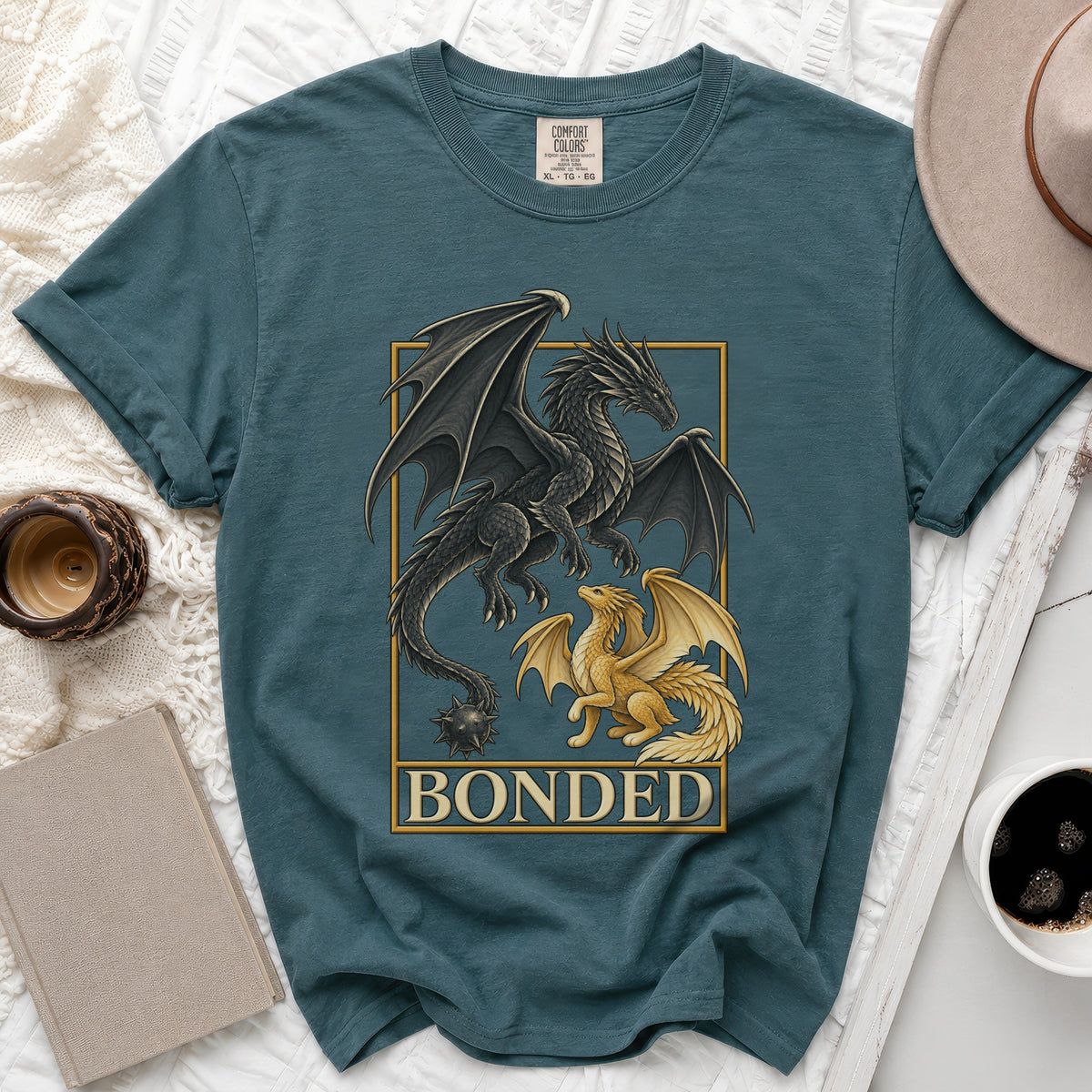Dark and golden dragons flanking "BONDED" text on a teal t-shirt.