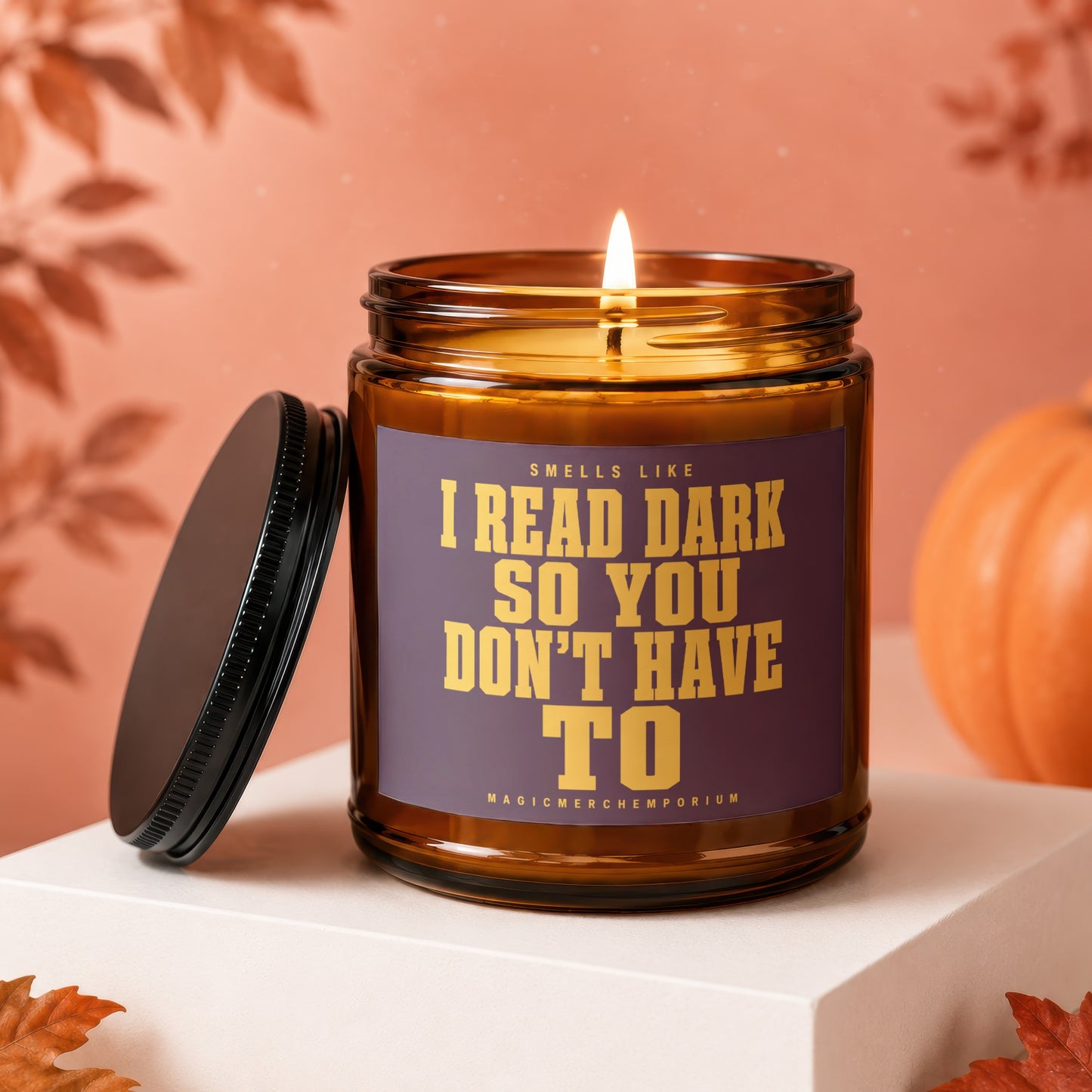 Lit candle in amber jar with text "Smells like I read dark so you don't have to".