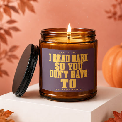 Lit candle in amber jar with text "Smells like I read dark so you don't have to".