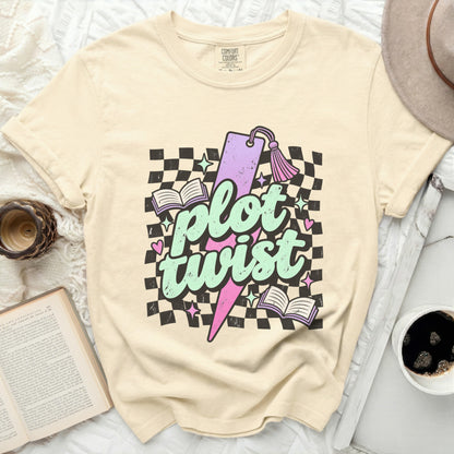 Cream t-shirt with "plot twist" text, lightning bolt, bookmark, and books.
