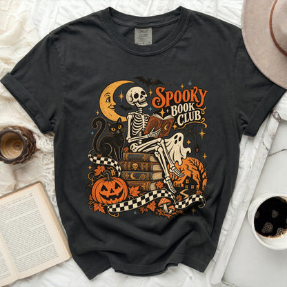 Skeleton reading book with "Spooky Book Club" text, moon, cat, pumpkin.