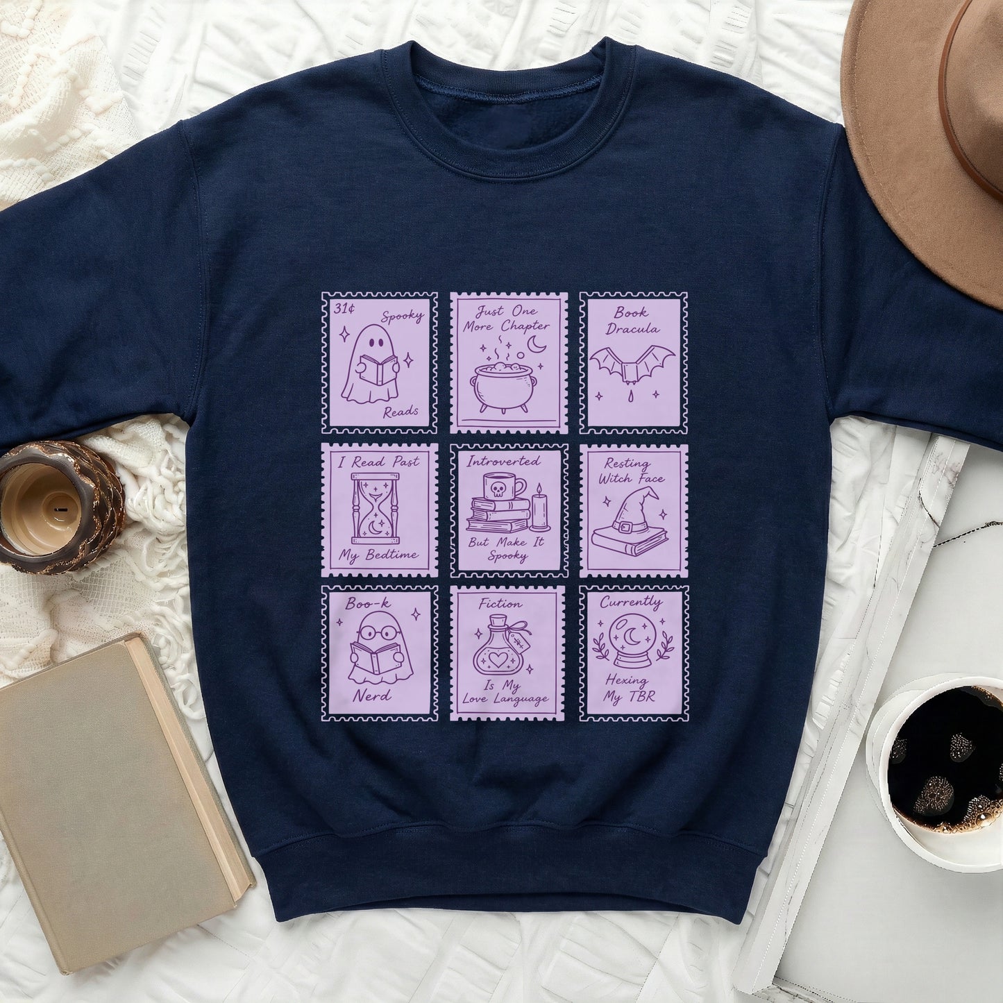 Navy sweatshirt with nine purple stamps featuring book and Halloween-themed illustrations and text.