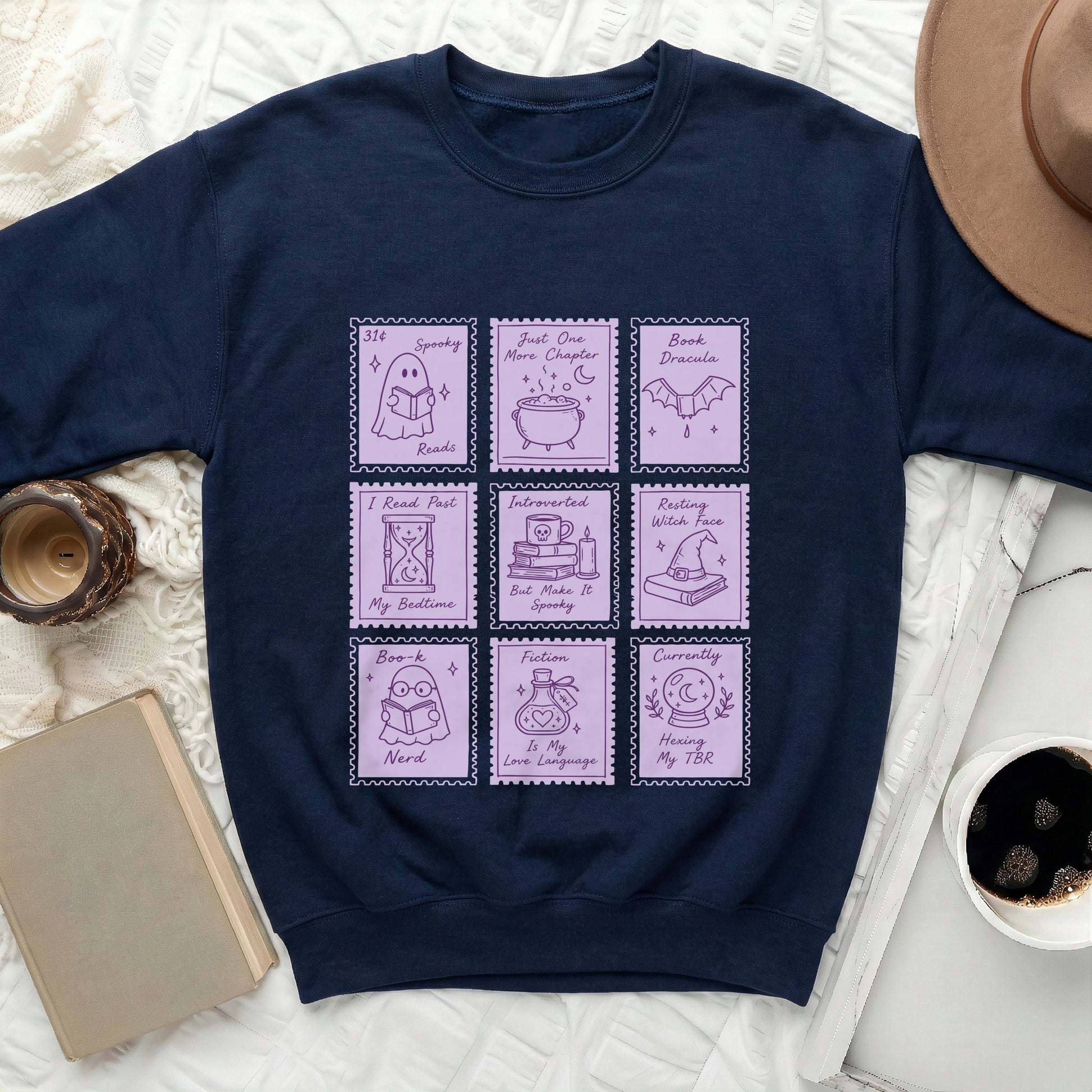 Navy sweatshirt with nine purple stamps featuring book and Halloween-themed illustrations and text.
