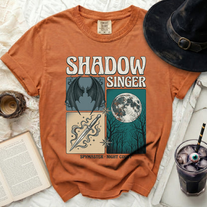 Orange t-shirt with "Shadow Singer Spymaster Night Court" graphic.