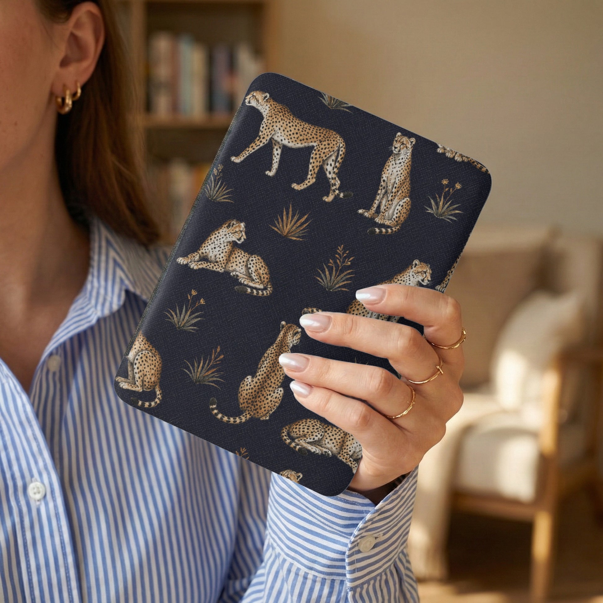 Dark blue case with cheetah pattern and gold accents held by a woman.