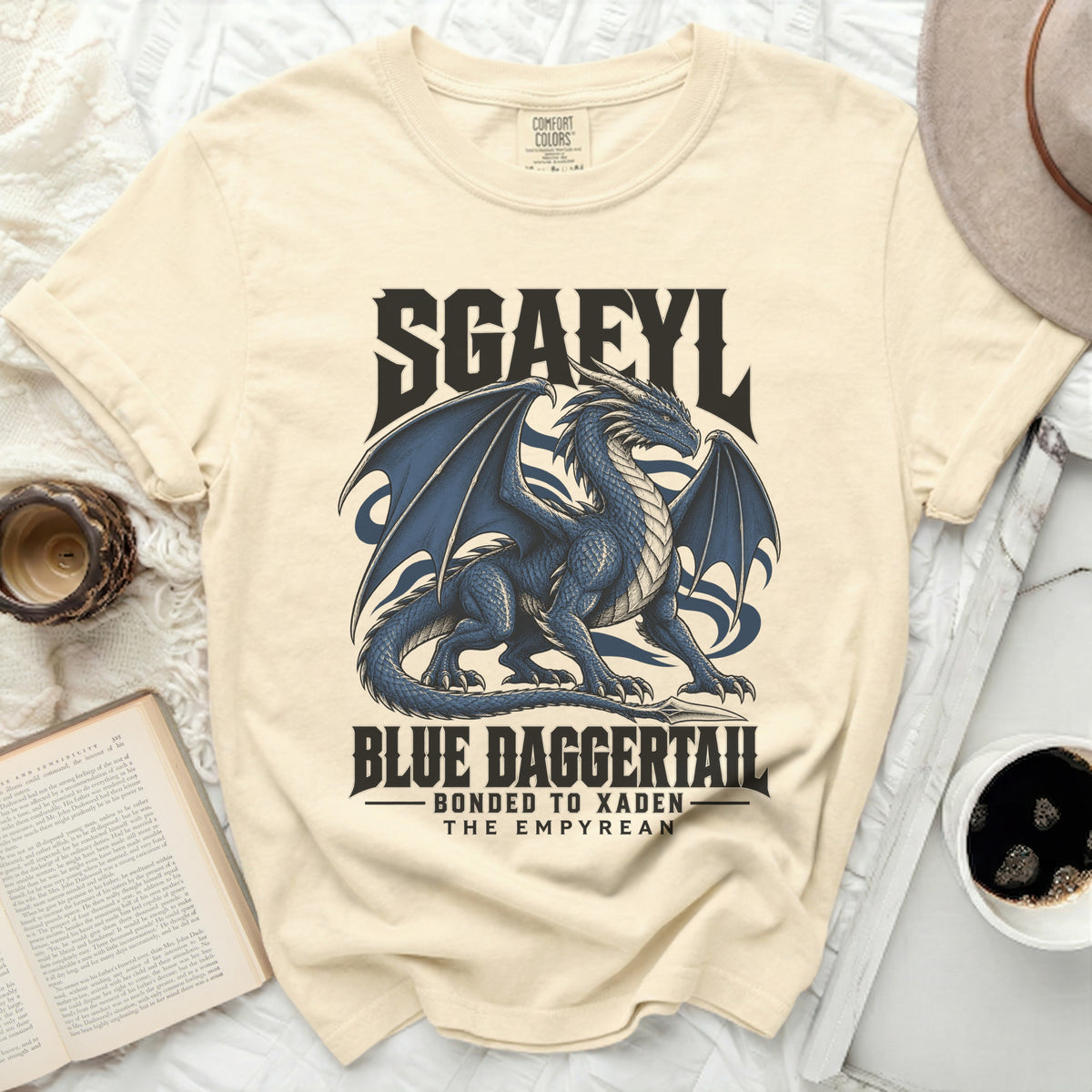 Cream t-shirt with blue dragon graphic and text "SGAFYL BLUE DAGGERTAIL BONDED TO XADEN THE EMPYREAN".
