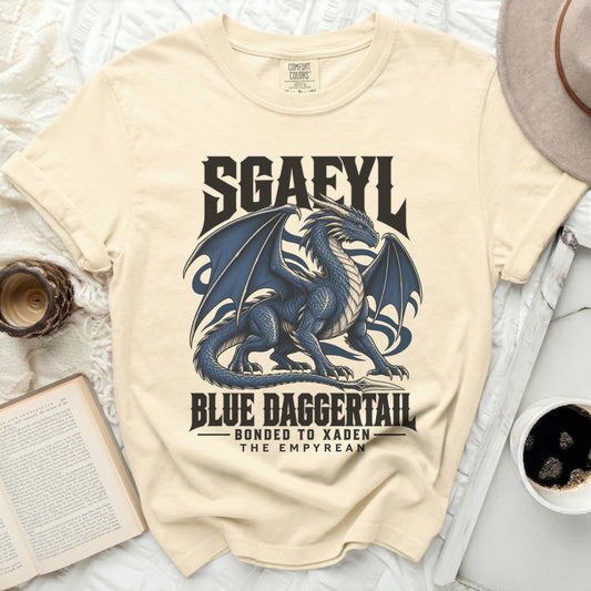 Cream t-shirt with blue dragon graphic and text "SGAFYL BLUE DAGGERTAIL BONDED TO XADEN THE EMPYREAN".