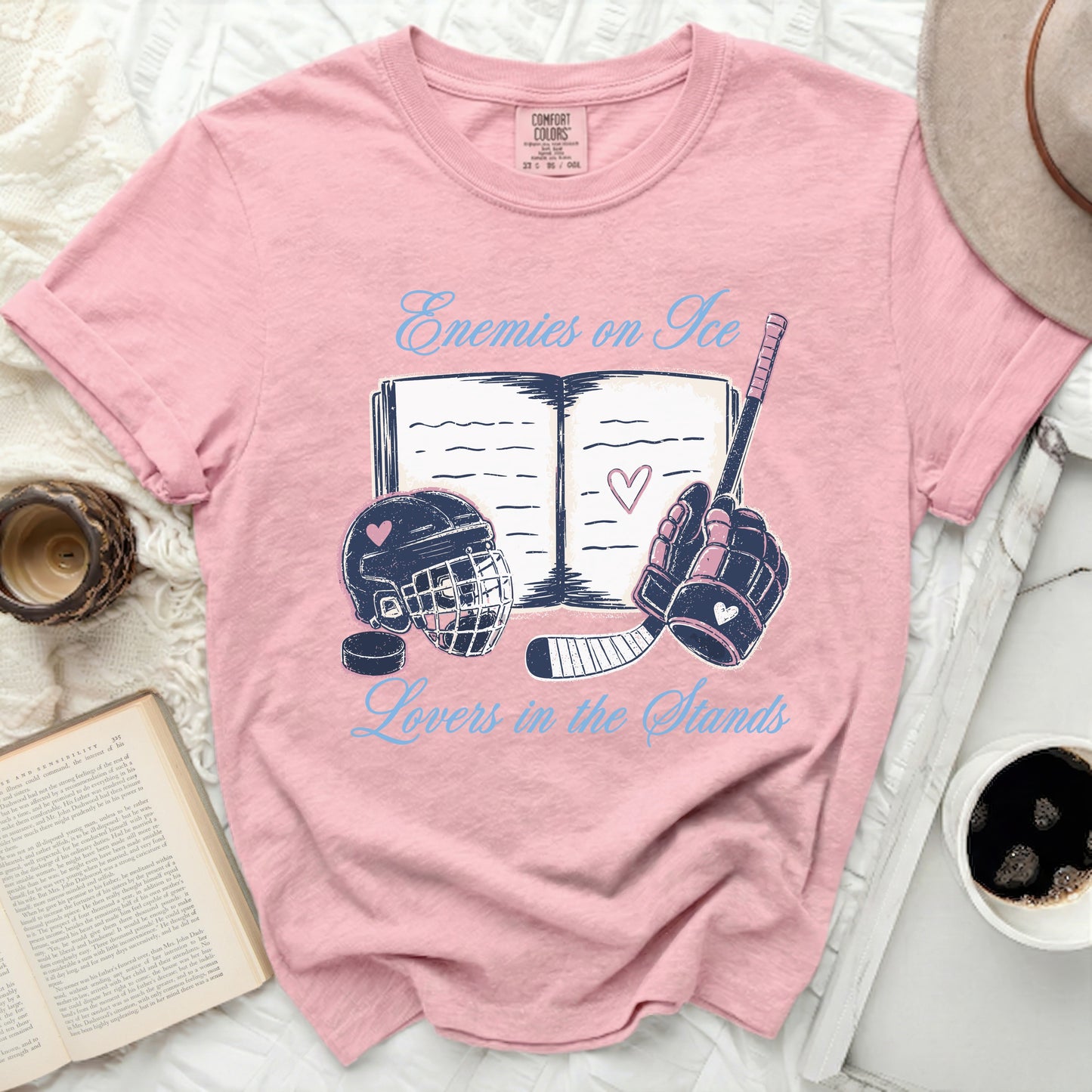 Pink t-shirt with "Enemies on Ice Lovers in the Stands" hockey graphic.