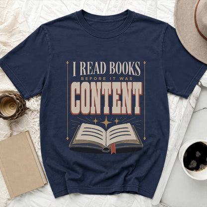 Navy t-shirt with text "I READ BOOKS BEFORE IT WAS CONTENT" and an open book graphic.