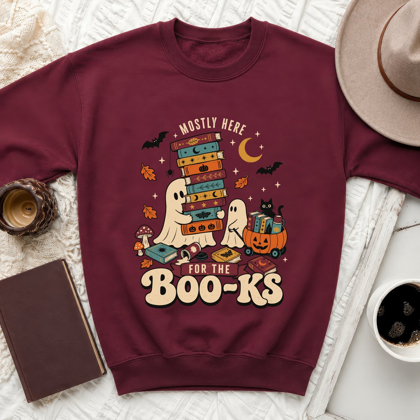 Maroon sweatshirt with ghosts and books graphic that reads "Mostly Here For The Boo-Ks".