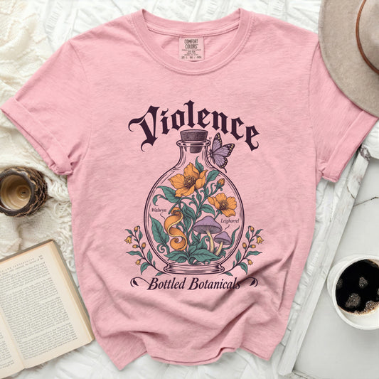 Pink short-sleeve t-shirt featuring a vintage graphic of a glass bottle containing flowers and mushrooms with butterfly and text.