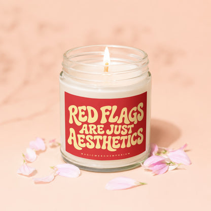 Candle with lit wick and label saying "Red flags are just aesthetics."