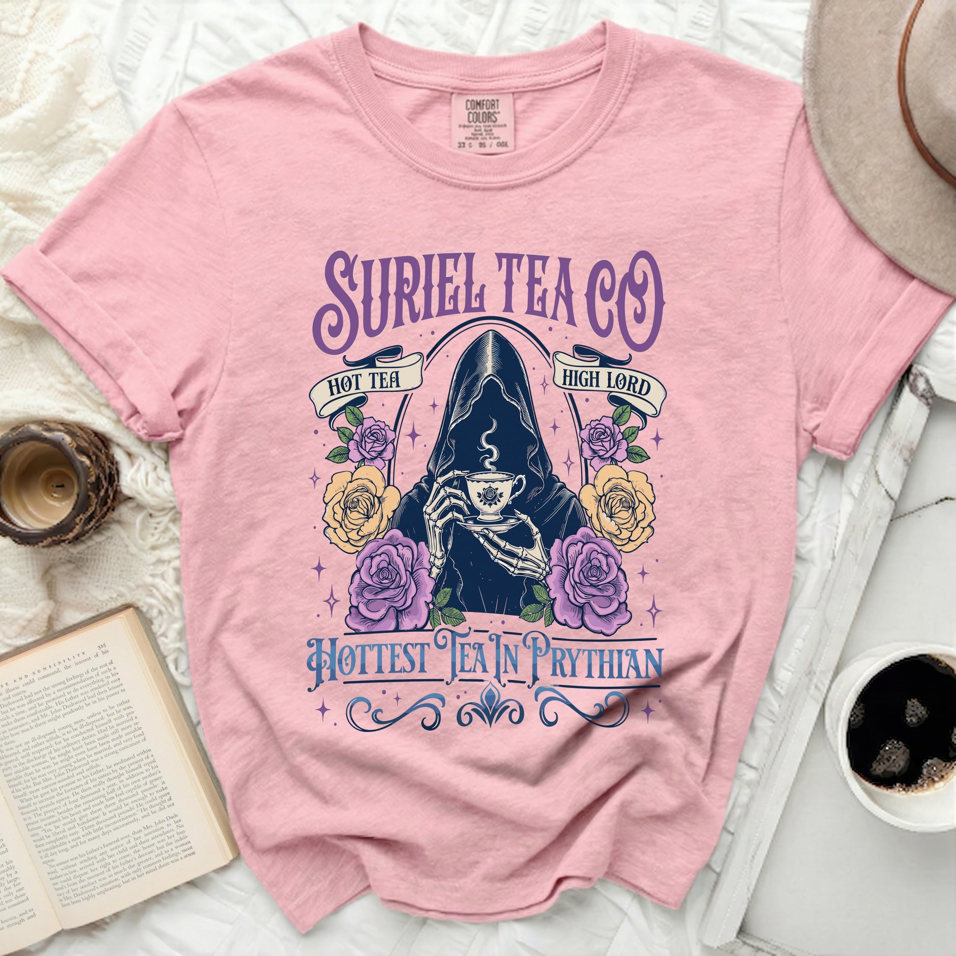Pink t-shirt with Suriel Tea Co. Grim Reaper graphic and floral accents.