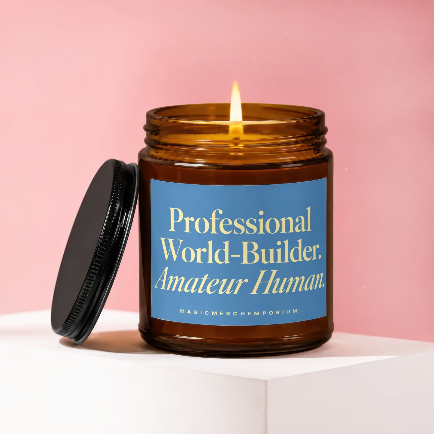 Burning candle in amber jar with blue label reading "Professional World-Builder. Amateur Human."