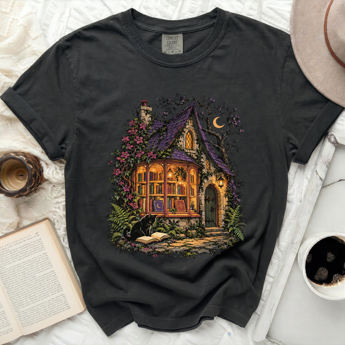 T-shirt with a mystical illustration of a cottage library and a black cat.