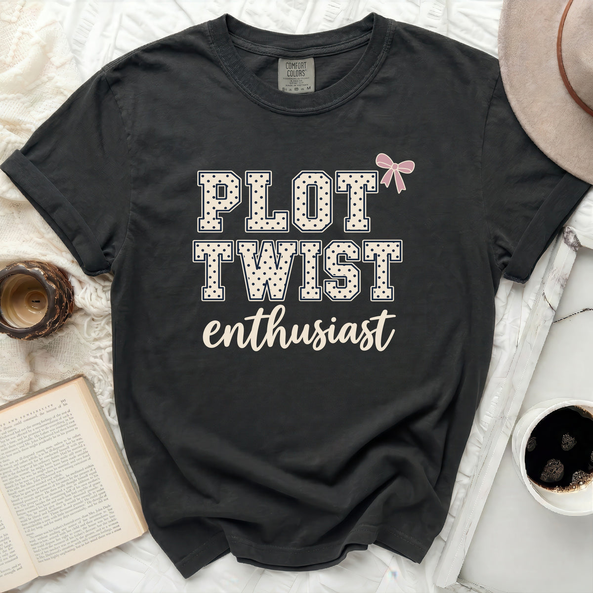 Black t-shirt with "PLOT TWIST enthusiast" text and a pink bow.