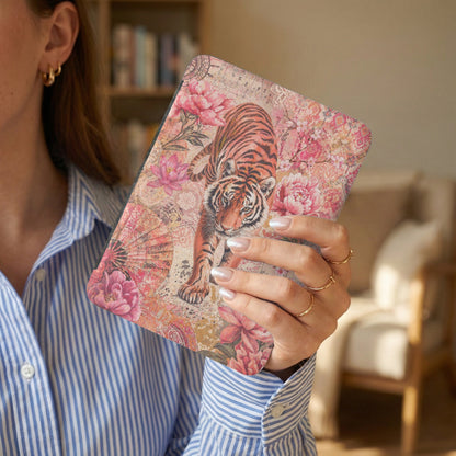 Book cover with a tiger, pink flowers, and ornate patterns, held by a woman.