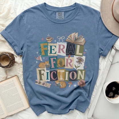 Feral for Fiction text with cats reading and books on a blue t-shirt.