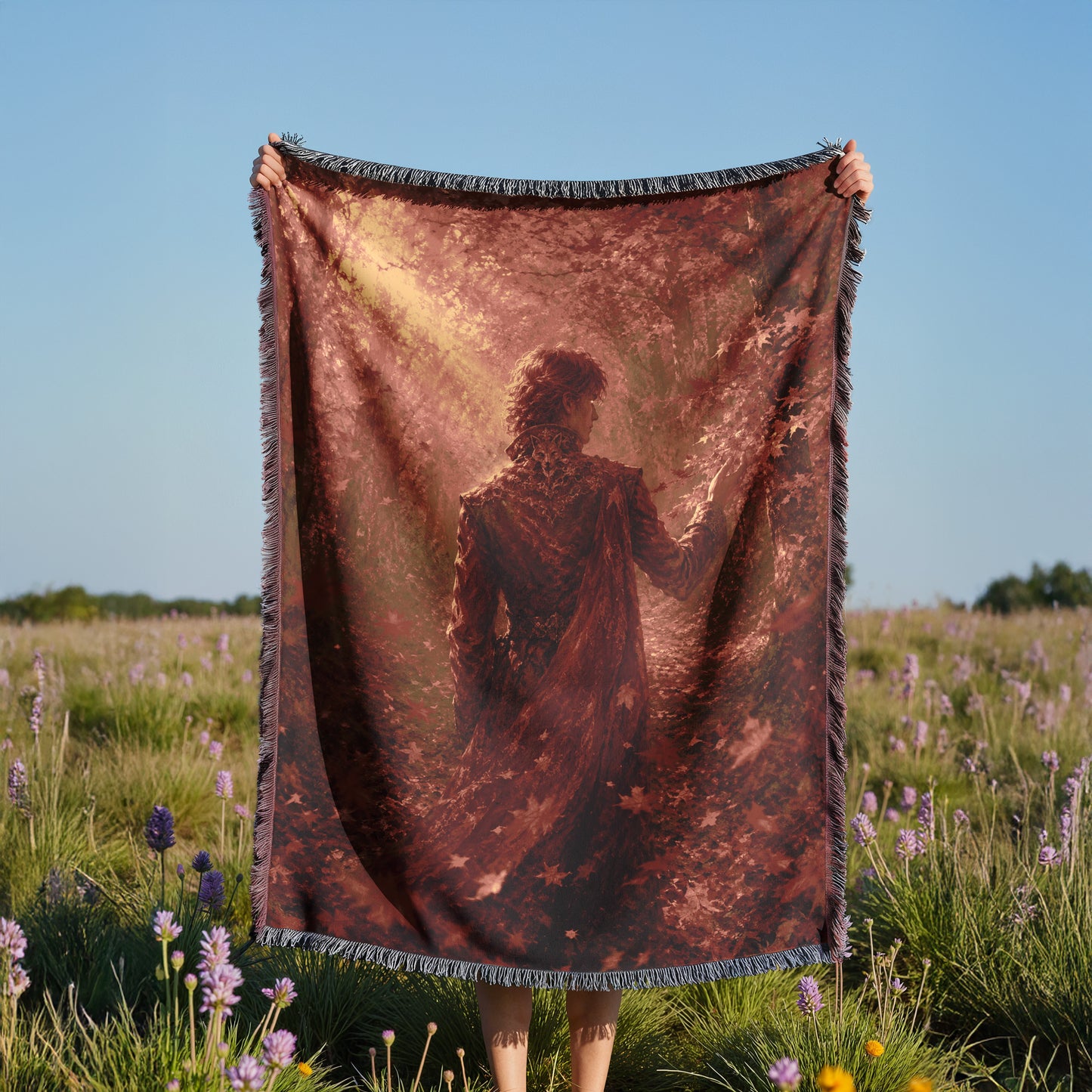 A person is holding a large blanket with a printed image of a person in a field of flowers.