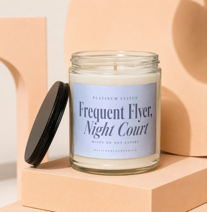 Glass candle with a black lid, labeled "Frequent Flyer, Night Court".