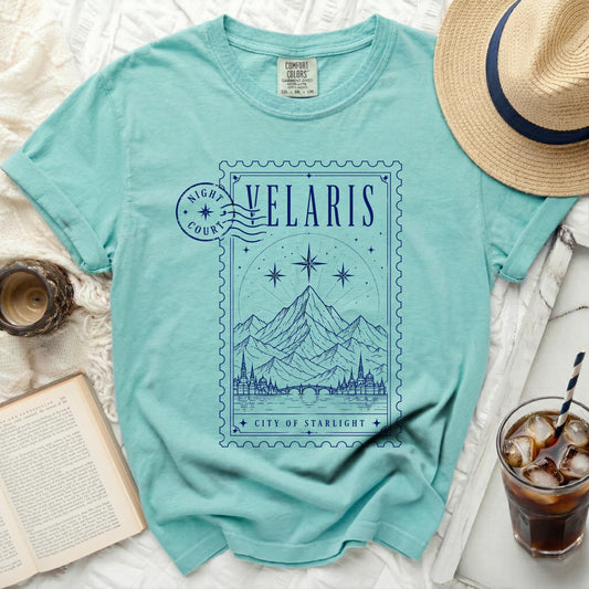 Turquoise t-shirt with a blue postage stamp graphic featuring "Velaris City of Starlight".