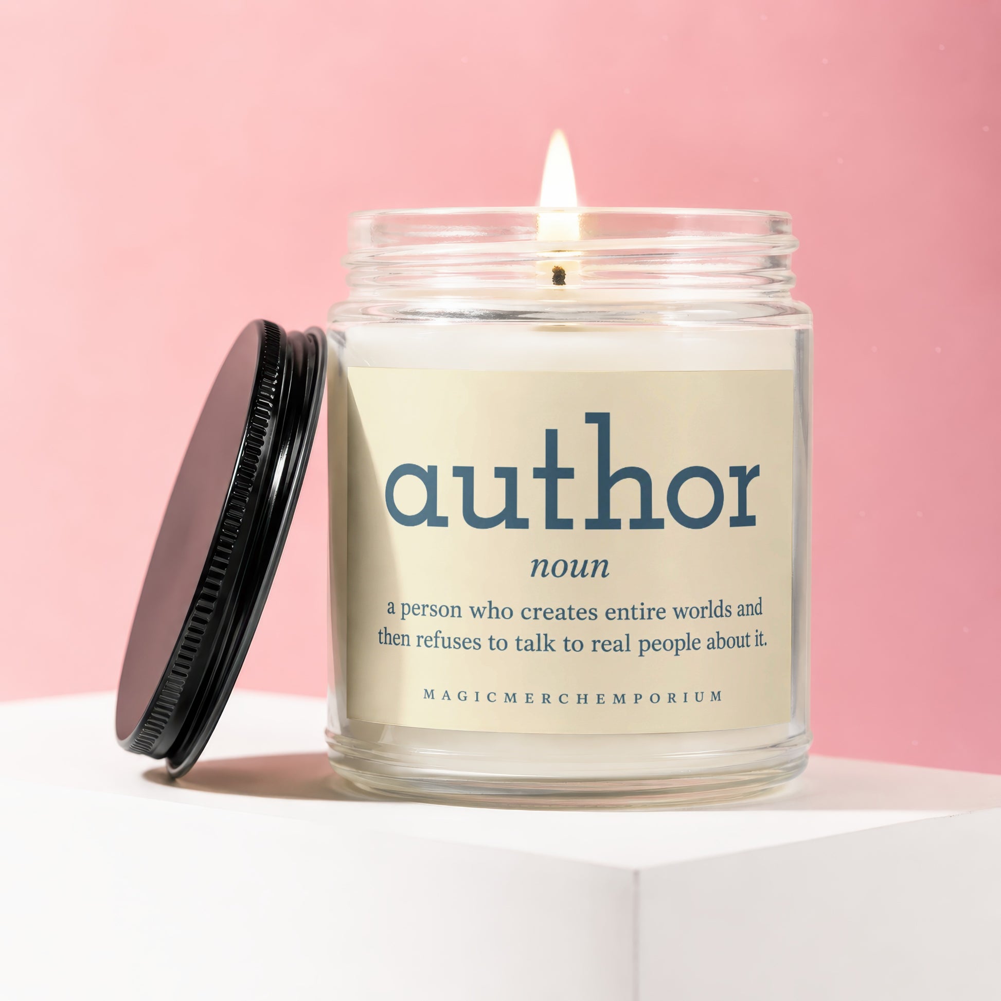 Candle with "author noun a person who creates entire worlds and then refuses to talk to real people about it." on label.