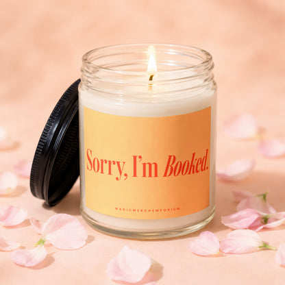 Lit candle with "Sorry, I'm Booked." text on orange label.