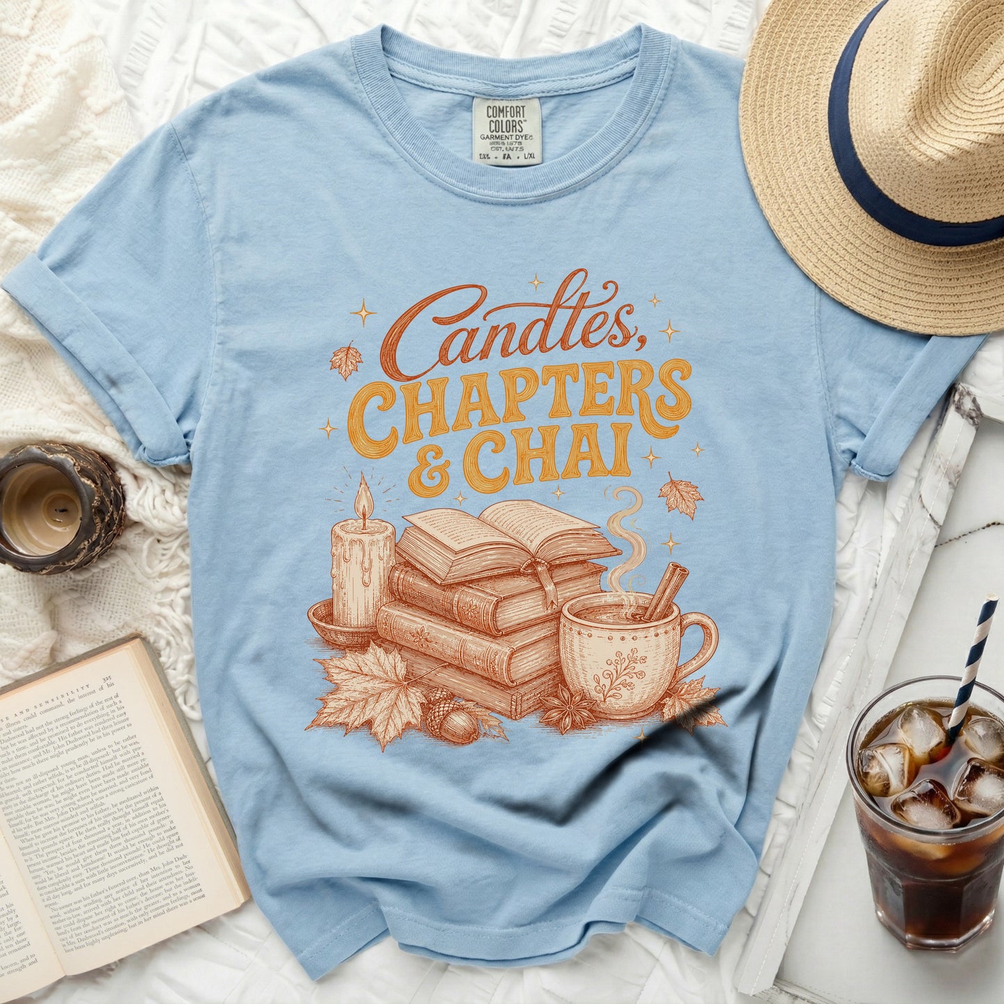 Light blue t-shirt with "Candles, Chapters & Chai" graphic.